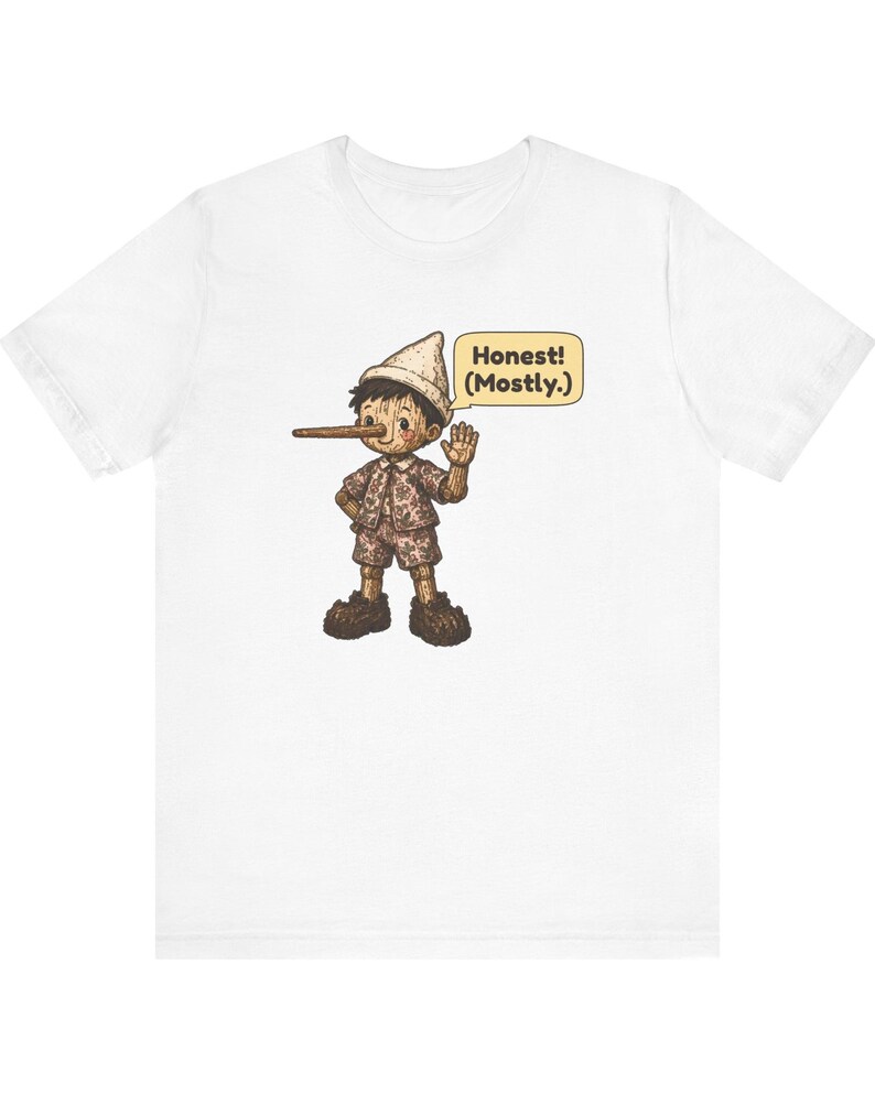 K&ouml;nnte beinhalten: Ein wei&szlig;es T-Shirt mit kurzen &Auml;rmeln und einer Grafik einer h&ouml;lzernen Marionettenfigur mit langer Nase, die einen Hut, ein Hemd und eine kurze Hose tr&auml;gt. Eine gelbe Sprechblase enth&auml;lt den schwarzen Text: Honest! (Mostly.)