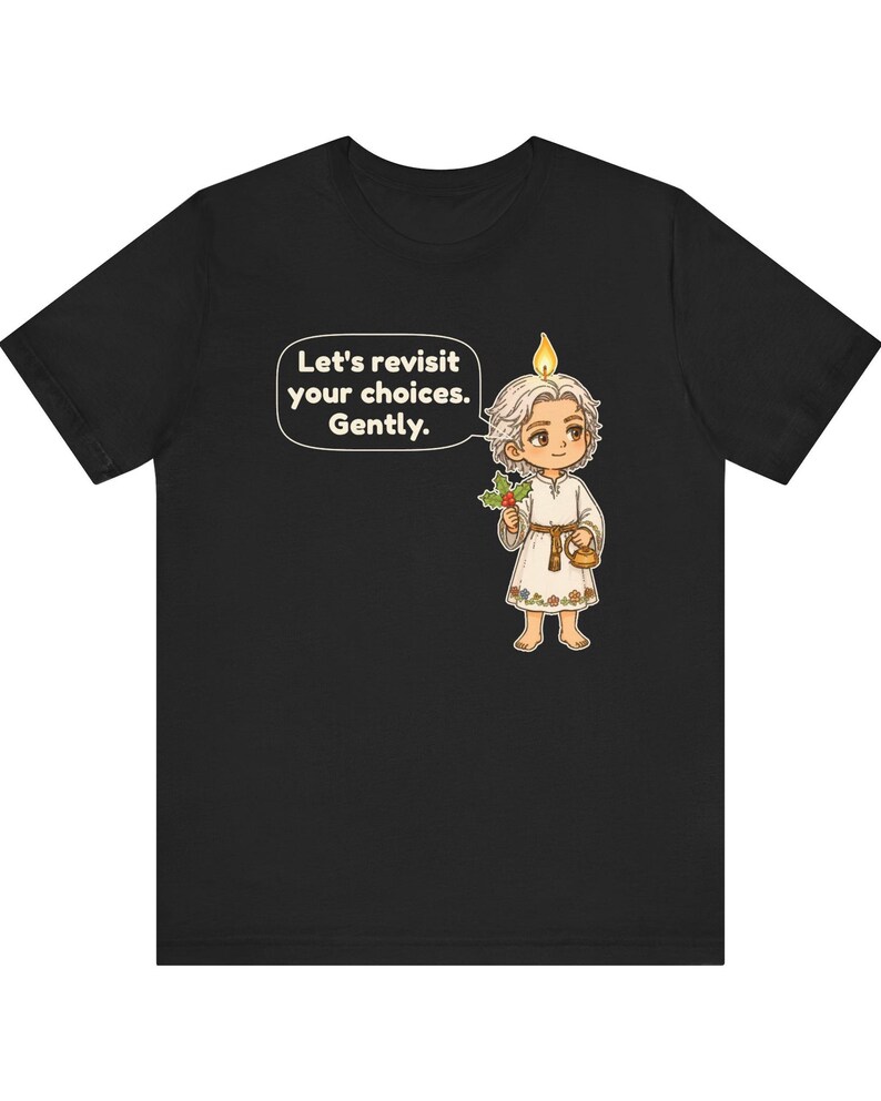 May include: A black t-shirt featuring a cartoon character with a candle flame on their head, holding a sprig of holly and a small lantern. A speech bubble contains the text: Let's revisit your choices. Gently. The character wears a white tunic.