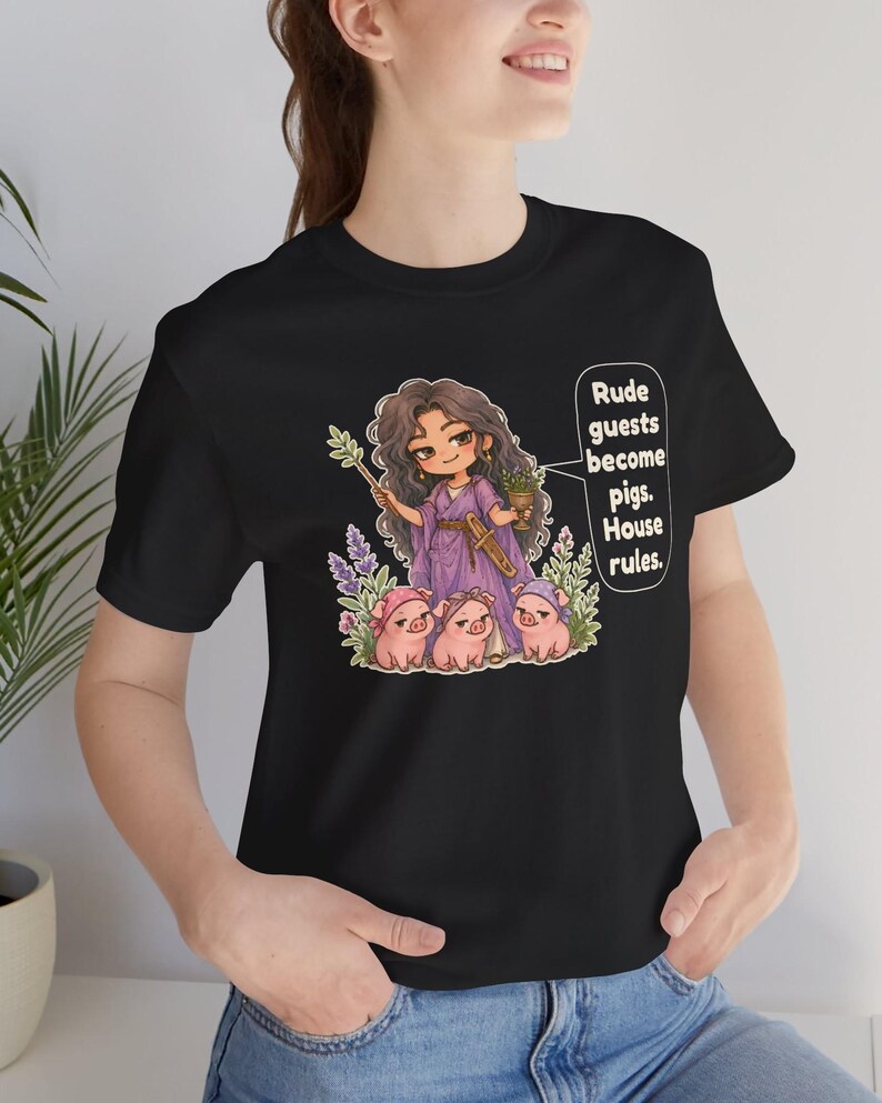 May include: A black t-shirt featuring a graphic of a character with long dark hair in a purple robe holding a wand and a small plant, surrounded by three small pigs wearing headbands, with the text: Rude guests become pigs. House rules.