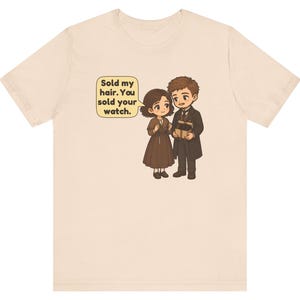 May include: A beige t-shirt featuring a cartoon illustration of a couple. The female character wears a brown dress, and the male character wears a dark suit. A speech bubble contains the text: Sold my hair. You sold your watch.