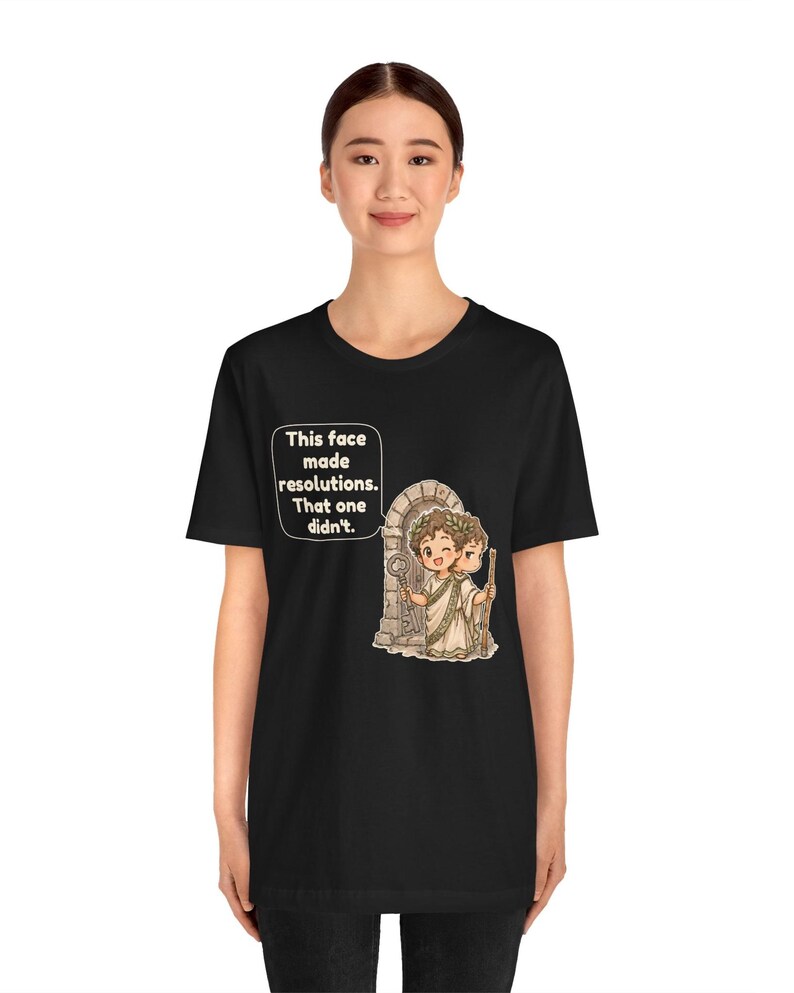 K&ouml;nnte beinhalten: Ein schwarzes T-Shirt mit einer Grafik von zwei Cartoon-Figuren in antiker Kleidung vor einem Steinbogen. Eine Figur h&auml;lt einen Schl&uuml;ssel, die andere einen Stab. Eine Sprechblase enth&auml;lt den Text: This face made resolutions. That one didn't.