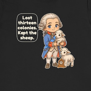 May include: A black t-shirt featuring a cartoon illustration of a historical figure in a blue coat and white breeches holding a white lamb, with another lamb and a small clock nearby. A speech bubble contains the text: Lost thirteen colonies. Kept the sheep.