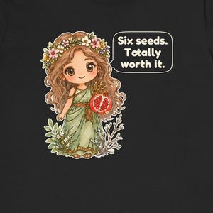 May include: A black t-shirt featuring a cartoon illustration of a character with long brown hair wearing a flower crown and a green dress. The character holds a pomegranate and a speech bubble reads: Six seeds. Totally worth it.