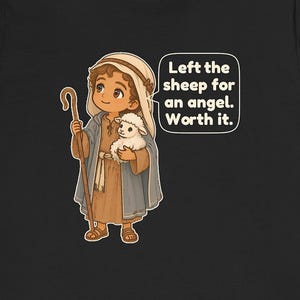 May include: A black t-shirt featuring a cartoon illustration of a shepherd wearing a tan tunic and blue cloak, holding a wooden staff and a small white sheep. A speech bubble contains the text: Left the sheep for an angel. Worth it.