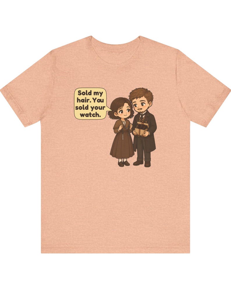 May include: A peach-colored t-shirt featuring a cartoon illustration of a couple holding a gift box. A speech bubble above the female character contains the text: Sold my hair. You sold your watch. The characters are dressed in brown and dark clothing.