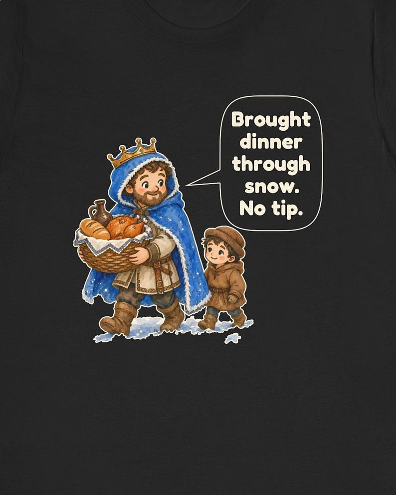 May include: A black t-shirt featuring a cartoon illustration of a person in a blue cloak and gold crown carrying a basket of food, accompanied by a child. A speech bubble contains the text: Brought dinner through snow. No tip.