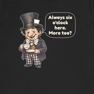 May include: A black t-shirt featuring a graphic of a character wearing a top hat, a polka dot bow tie, and checkered pants, holding a teacup and saucer. A speech bubble next to the character contains the text: Always six o'clock here. More tea?