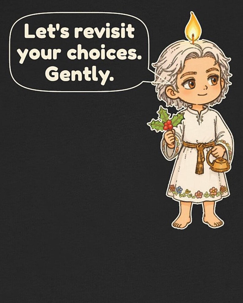 May include: A black t-shirt featuring a cartoon character with a candle flame on their head, holding holly and a small gold kettle. A speech bubble contains the text: Let's revisit your choices. Gently. The character wears a white tunic with floral embroidery.