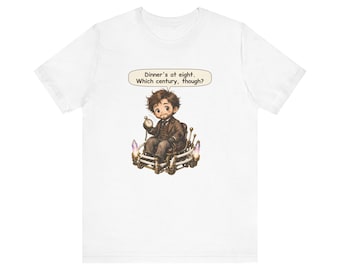 May include: A white t-shirt featuring a graphic of a person with brown hair sitting in a mechanical chair, holding a pocket watch. A speech bubble above the character contains the text: Dinner's at eight. Which century, though?