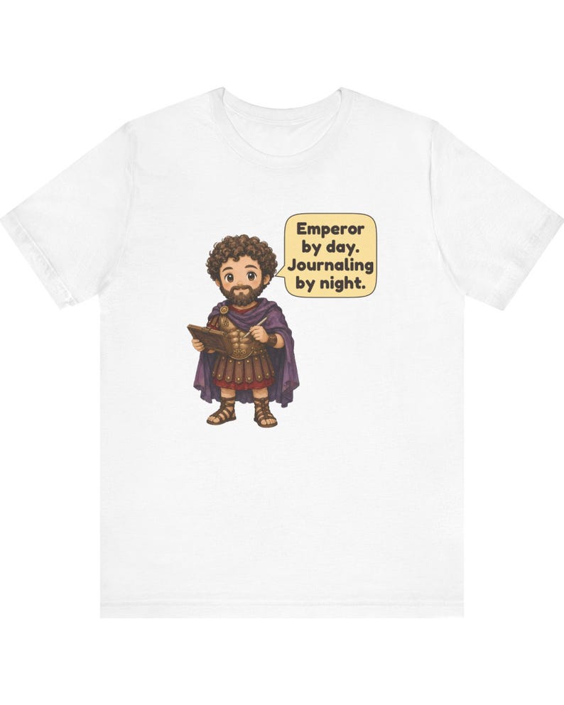 K&ouml;nnte beinhalten: Ein wei&szlig;es T-Shirt mit einer Cartoon-Illustration eines b&auml;rtigen Kaisers in r&ouml;mischer R&uuml;stung und violettem Umhang, der ein Tagebuch und einen Stift h&auml;lt. Eine Sprechblase enth&auml;lt den Text: Emperor by day. Journaling by night.