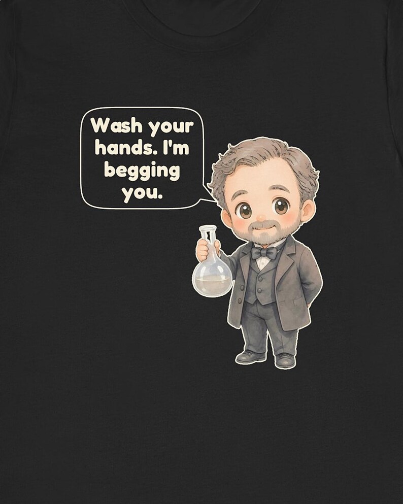 May include: A black t-shirt featuring a cartoon illustration of a man with a beard wearing a grey suit and bowtie. He holds a glass flask containing a light-colored liquid. A speech bubble above him contains the text: Wash your hands. I'm begging you.