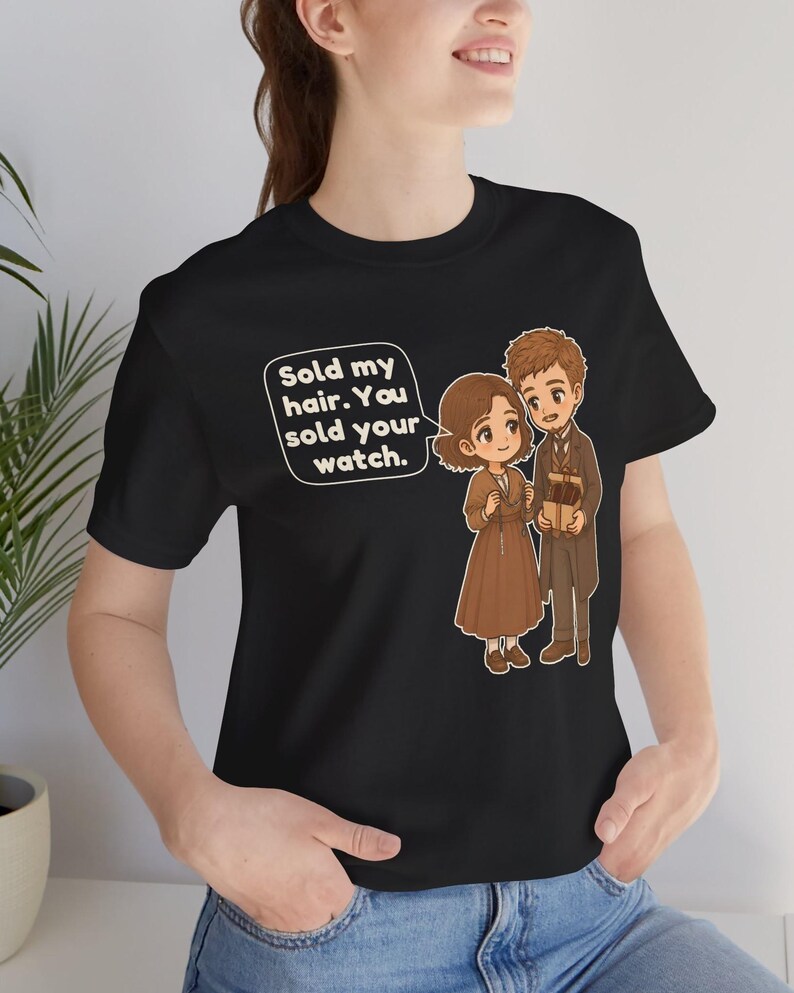 May include: A black t-shirt featuring a graphic of two cartoon characters in brown clothing. One character holds a small box, and a speech bubble contains the text: Sold my hair. You sold your watch. The design is centered on the chest area.