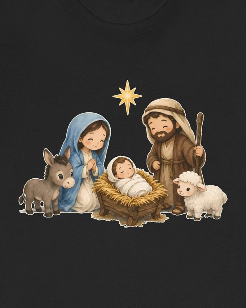 May include: A black t-shirt featuring a graphic of a nativity scene with a baby in a manger, a person in a blue head covering, a person in a brown robe with a staff, a donkey, a white sheep, and a yellow star against a dark background.