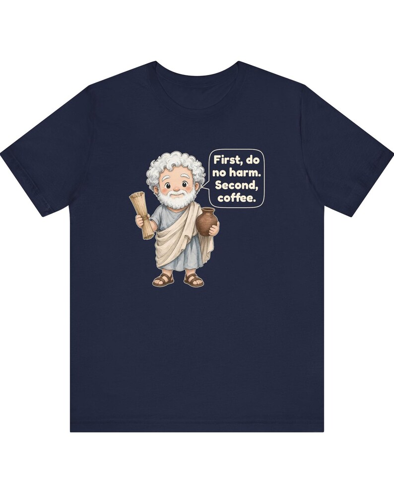 May include: A navy blue t-shirt featuring a cartoon illustration of a white-haired, bearded figure in a light gray toga holding a scroll and a brown pot, with a speech bubble containing the text: First, do no harm. Second, coffee.