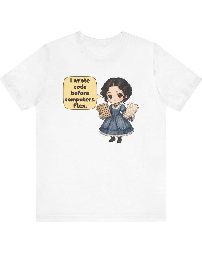 May include: A white t-shirt featuring a cartoon illustration of a person in a dark blue Victorian-style dress holding punch cards and papers. A yellow speech bubble contains the text: I wrote code before computers. Flex.