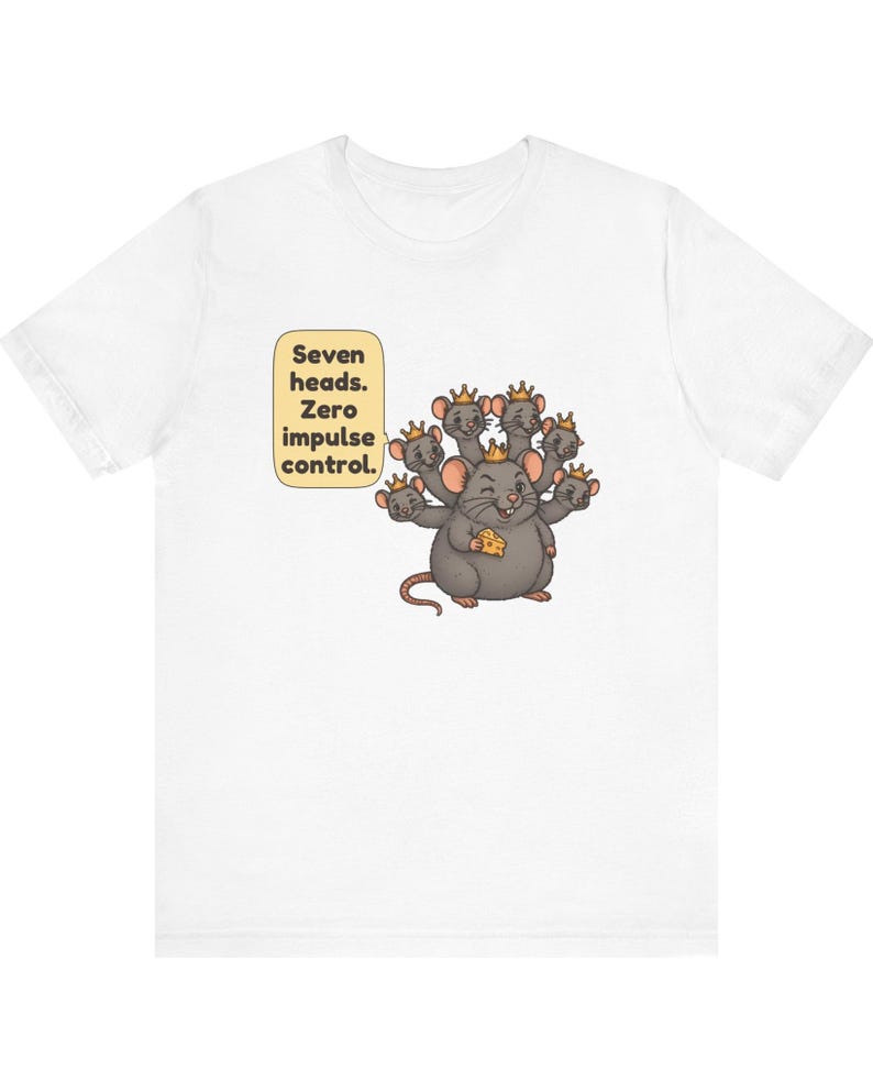 May include: A white t-shirt featuring a graphic of a gray rat with seven heads, each wearing a small gold crown. The rat holds a piece of yellow cheese. A speech bubble next to the rat contains the text: Seven heads. Zero impulse control.