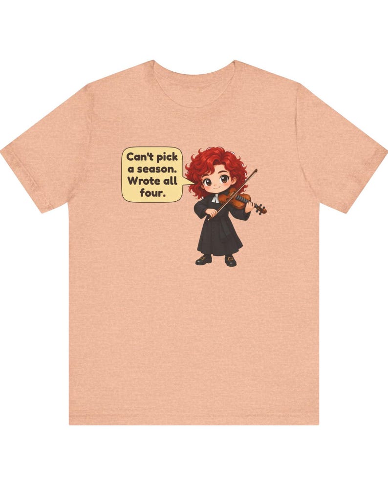 May include: A peach-colored t-shirt featuring a cartoon illustration of a red-haired character playing a violin. A speech bubble next to the character contains the text: Can't pick a season. Wrote all four.