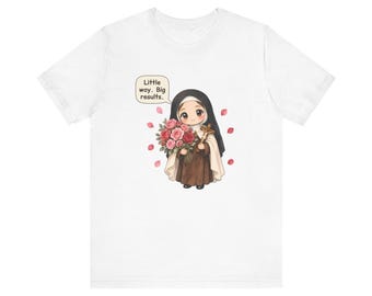 May include: A white t-shirt featuring a cartoon illustration of a nun in a brown habit holding a bouquet of pink and red roses and a crucifix. A speech bubble above the figure contains the text, Little way. Big results. Pink petals float around.