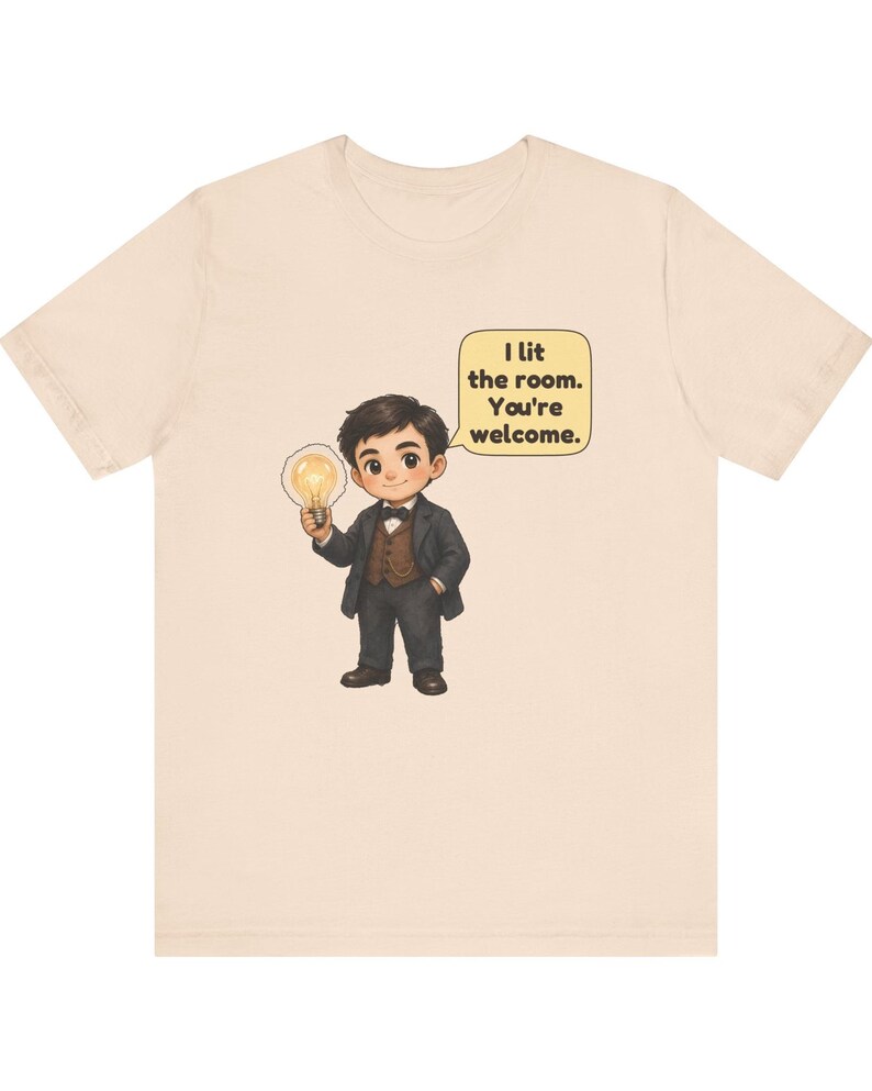 Może przedstawiać: Beżowy t-shirt z rysunkową ilustracją osoby w ciemnym garniturze i muszce, trzymającej świecącą żar&oacute;wkę. Dymek obok postaci zawiera tekst: I lit the room. You're welcome.