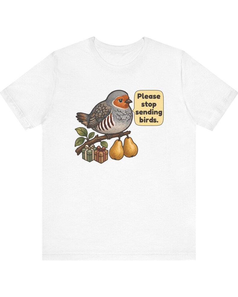 K&ouml;nnte beinhalten: Ein wei&szlig;es T-Shirt mit einer Grafik eines grauen und orangefarbenen Vogels, der auf einem Ast mit zwei Birnen und zwei kleinen Geschenkkartons sitzt. Eine Sprechblase neben dem Vogel enth&auml;lt den Text, Please stop sending birds.