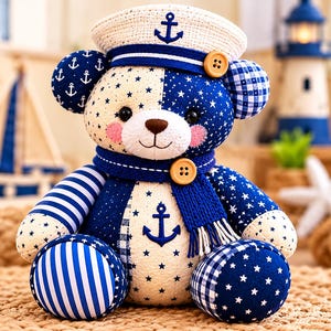 May include: A plush teddy bear featuring a patchwork design of navy blue and cream fabric with star, anchor, and plaid patterns. The bear wears a matching sailor hat with an anchor emblem and a blue knit scarf secured by a wooden button.