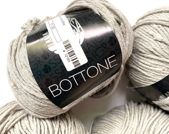 May include: Three skeins of light gray yarn labeled "BOTTONE" with the color name "Gay Grey" and the number "12163".