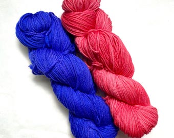 May include: Two skeins of yarn, one blue and one pink, are twisted together.