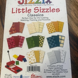 Pode incluir: Pacote de cartolina Sizzix Little Sizzles Classics com 80 folhas sem ácido em várias cores e padrões. A embalagem exibe uma máquina de corte vermelha, cartões de amostra, um código de barras e texto descritivo.