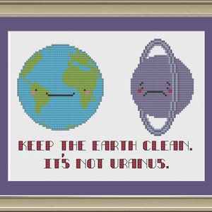 以下が含まれることがあります： 地球と天王星が描かれたクロスステッチのパターン。地球は笑顔で、天王星はしかめっ面をしています。テキストには「Keep the Earth clean. It's not Uranus.」と書いてあります。