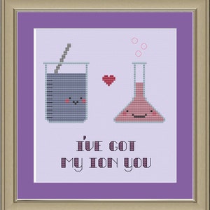 Puede incluir: Un patrón de punto de cruz con dos vasos de precipitados con caras, un corazón y el texto "I've got my ion you".