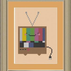 Könnte beinhalten: Eine pixelartige Cartoon-Illustration eines Vintage-Fernsehers mit einem bunten Testmuster auf dem Bildschirm. Der Fernseher hat ein lächelndes Gesicht mit rosa Wangen und einem schwarzen Mund.