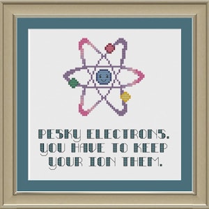 May include: A cross-stitch pattern with a colorful atom design and the text "PESKY ELECTRONS. YOU HAVE TO KEEP YOUR ION THEM."