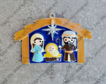 Könnte beinhalten: Ein blauer und goldener Weihnachtsanhänger, der die Weihnachtsgeschichte darstellt. Der Anhänger zeigt einen Stern, eine Krippe, Maria, Josef und das Jesuskind.