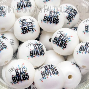 May include: A bowl of white round beads with the phrase "I Like Big Bulbs" printed on them. The beads have a string of colorful lights printed on them.