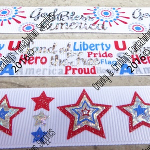 May include: White ribbons with patriotic designs. One ribbon features the text "God Bless America" with red and blue accents. Another has "Liberty" and "Proud" with a flag graphic. The third ribbon has red, silver, and blue stars.