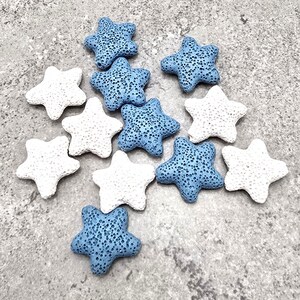 May include: A collection of star-shaped decorative objects in shades of white and blue. The stars have a porous texture and are scattered across a gray surface. These decorative stars are ideal for crafting or home decor projects.