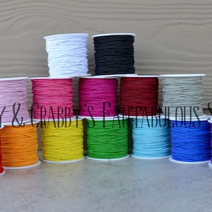 Puede incluir: Carretes de cordón elástico de colores en varios colores, incluyendo blanco, negro, rosa, rojo, naranja, amarillo, verde, azul, gris y morado. Cranky & Crabby's Fabulous Supplies.