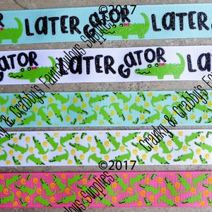 May include: Five different ribbon designs featuring a green alligator with the text "Later Gator" in black. The ribbons are in various colors, including blue, white, and pink. The ribbons are printed with a repeating pattern of alligators and yellow circles.