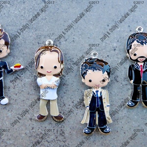 May include: Four metal charms featuring cartoon characters. Each charm is silver with black, white, red, and brown paint. The characters are wearing different outfits.