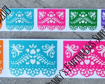Peut inclure: Un ruban avec un motif répété de découpes de papier colorées. Les découpes sont en forme de drapeau mexicain traditionnel avec un motif blanc sur un fond coloré. Les couleurs des découpes sont le violet, l'orange, le turquoise, le rose, le vert et la lavande.
