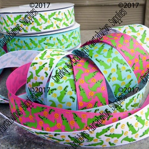 May include: Assortment of green alligator patterned ribbon in white, pink, and blue. The ribbon is 1.5 inches wide and is perfect for crafting, gift wrapping, and decorating.