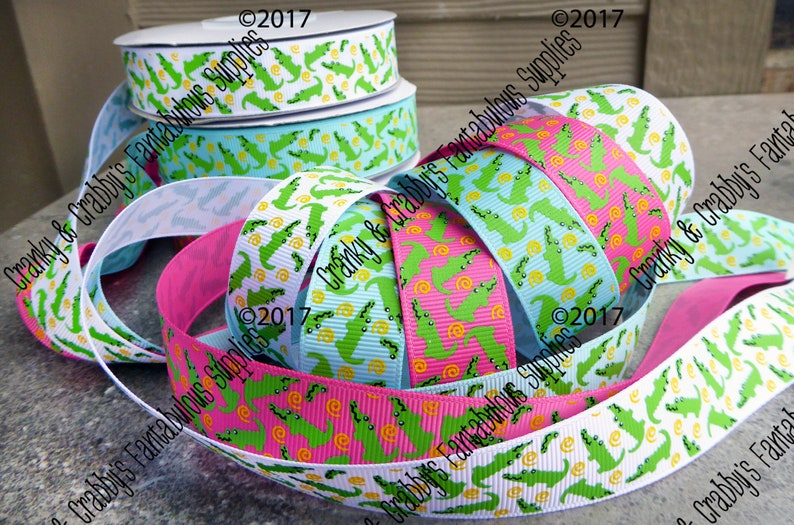 May include: Assortment of green alligator patterned ribbon in white, pink, and blue. The ribbon is 1.5 inches wide and is perfect for crafting, gift wrapping, and decorating.