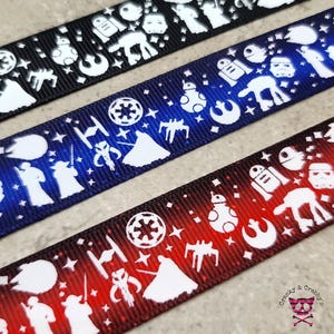 May include: Three different Star Wars themed ribbon designs. The first ribbon is black with white Star Wars characters and symbols. The second ribbon is blue with white Star Wars characters and symbols. The third ribbon is red with white Star Wars characters and symbols.