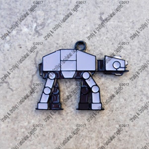 May include: A metal charm in the shape of an AT-AT walker from Star Wars. The charm is primarily white and black with a black loop at the top for attaching to a necklace or bracelet. The charm is a fun accessory.