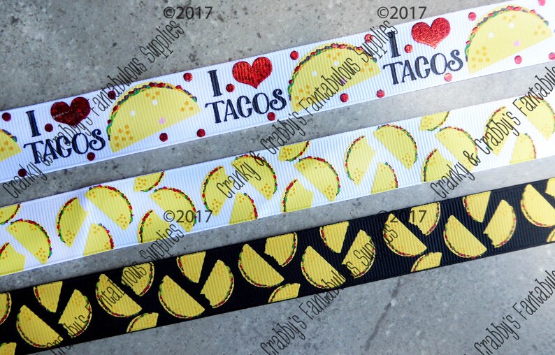 May include: Three different ribbon designs featuring a yellow taco pattern. The top ribbon is white with red hearts and the text "I love tacos". The middle ribbon is white with yellow tacos. The bottom ribbon is black with yellow tacos.