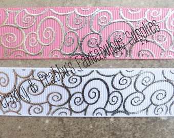 May include: Two samples of silver ribbon with a swirl pattern. The top ribbon is pink with silver swirls. The bottom ribbon is white with silver swirls.