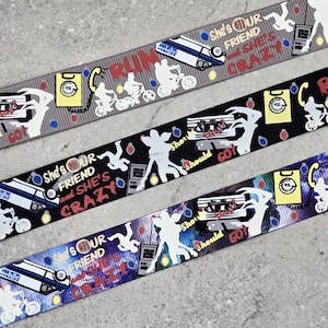 May include: Ribbon featuring various designs and text. The ribbons are gray, black, and blue. The designs include a car, bicycles, a telephone, and the text "RUN", "She's OUR FRIEND and SHE'S CRAZY", and "Show Should GO".