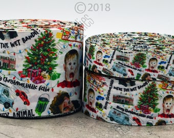 May include: A white ribbon with a repeating pattern of images and text from the movie Home Alone. The images include a Christmas tree, a house, a van, a boy, and a paint can. The text includes "We're the Wet Bandits" and "Merry Christmas, little fella".