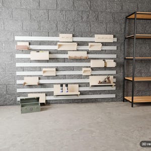 Puede incluir: Un sistema de almacenamiento modular montado en la pared con listones horizontales blancos y varios estantes, ganchos y cajas de madera clara. A la derecha hay una estanter&iacute;a alta de metal con estructura abierta y niveles de madera clara.