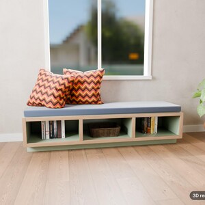 May include: A low rectangular storage bench with a light wood frame and a light blue seat cushion. Two square pillows with a red, orange, and black chevron pattern sit on the cushion. The base features three open cubbies containing books and a basket.